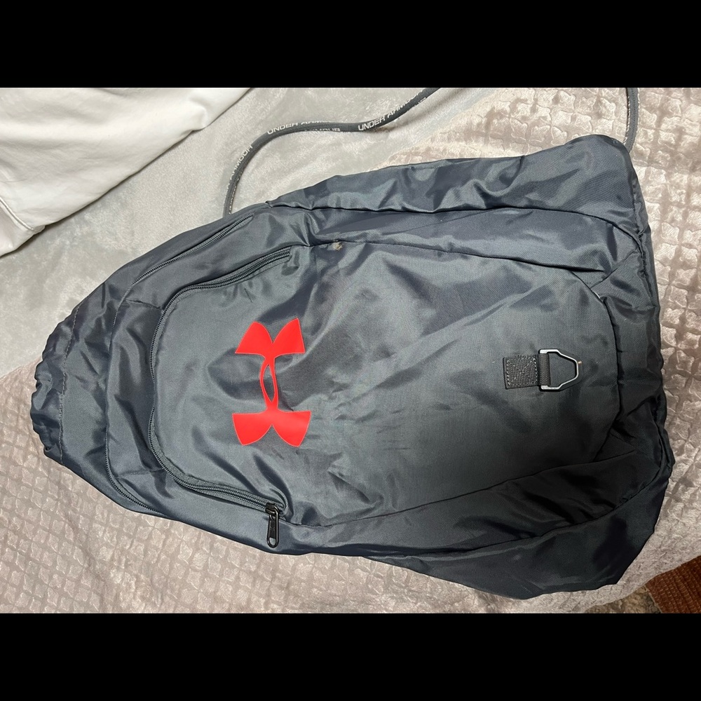 Under Armour drawstring backpack.... Grey in color with orangish red UA symbol.